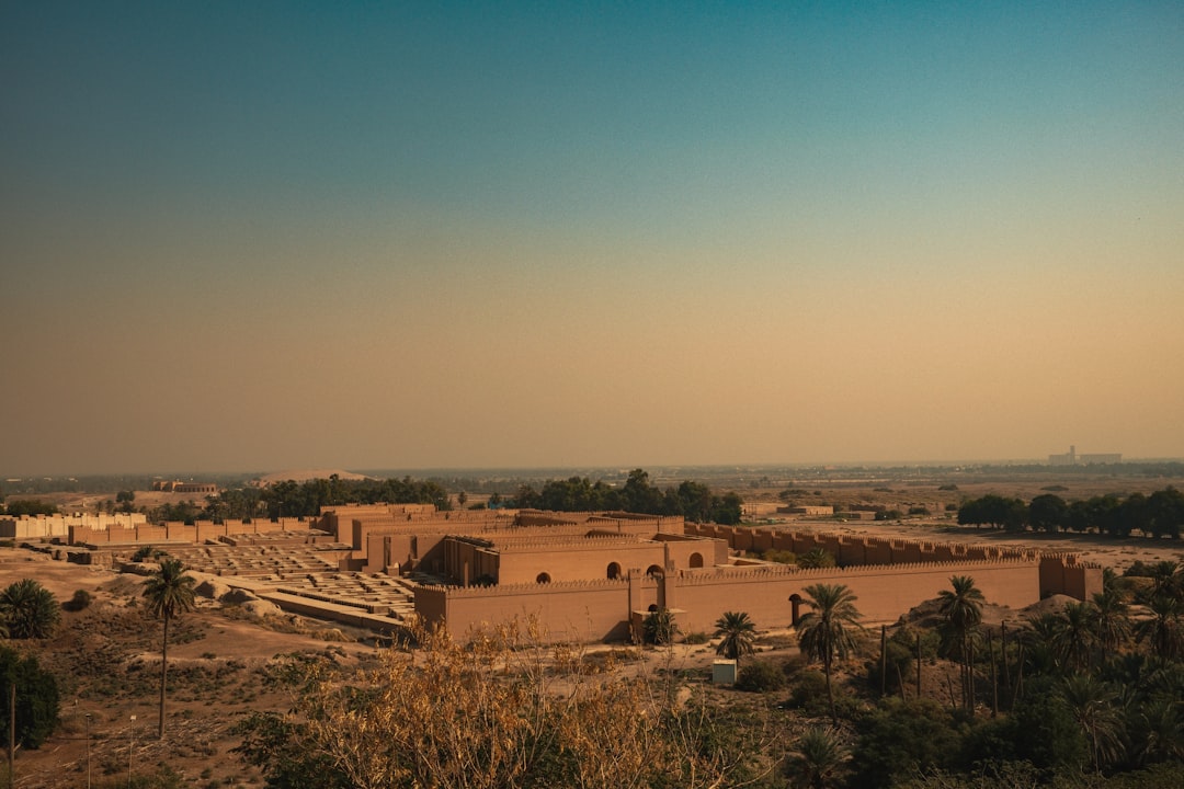 Ruins of an ancient Mesopotamian palace complex with palm trees