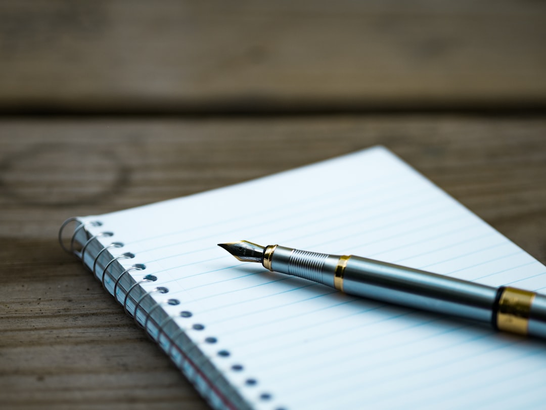 Fountain pen resting on a handwritten poetry manuscript