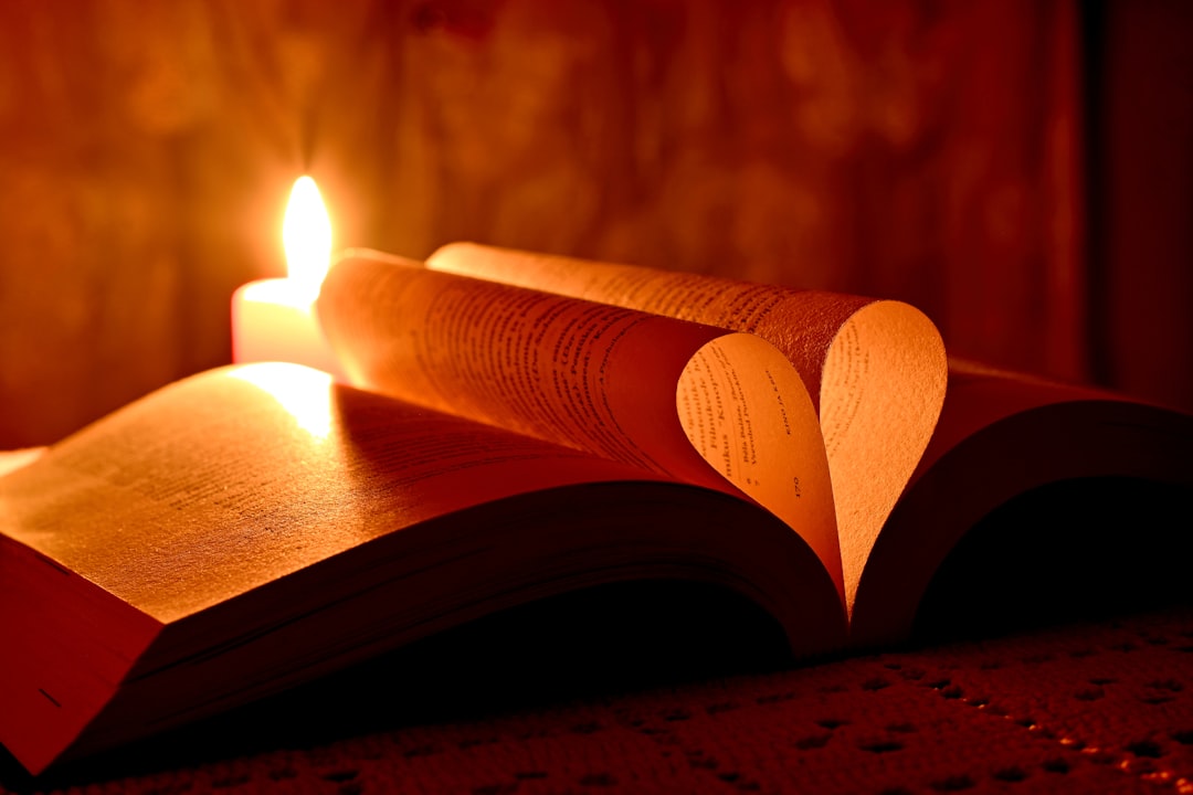 Open poetry book lit by candlelight